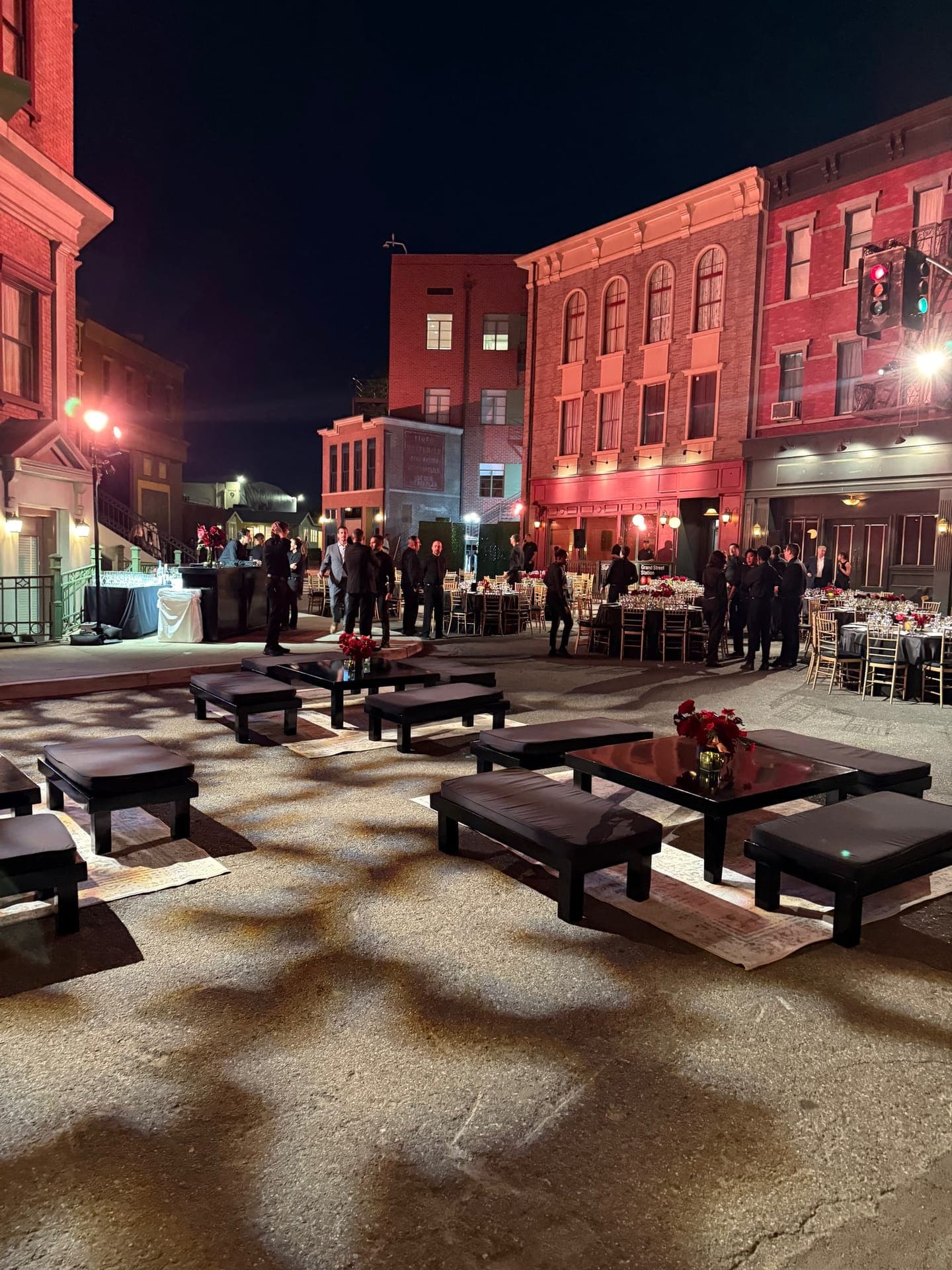 Studio backlot street set with low lounge tables and red florals