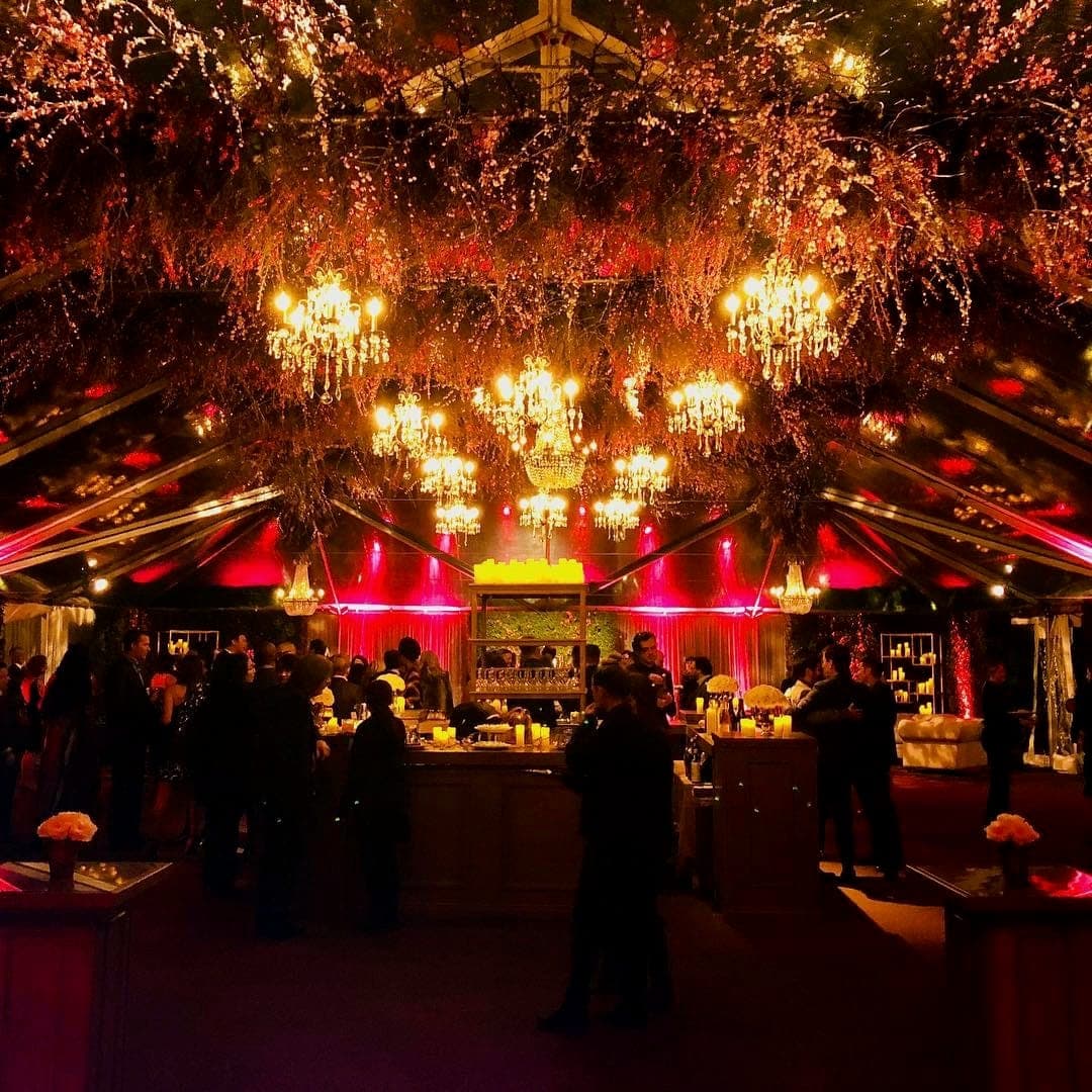 Clear-top tent reception with chandeliers and hanging florals