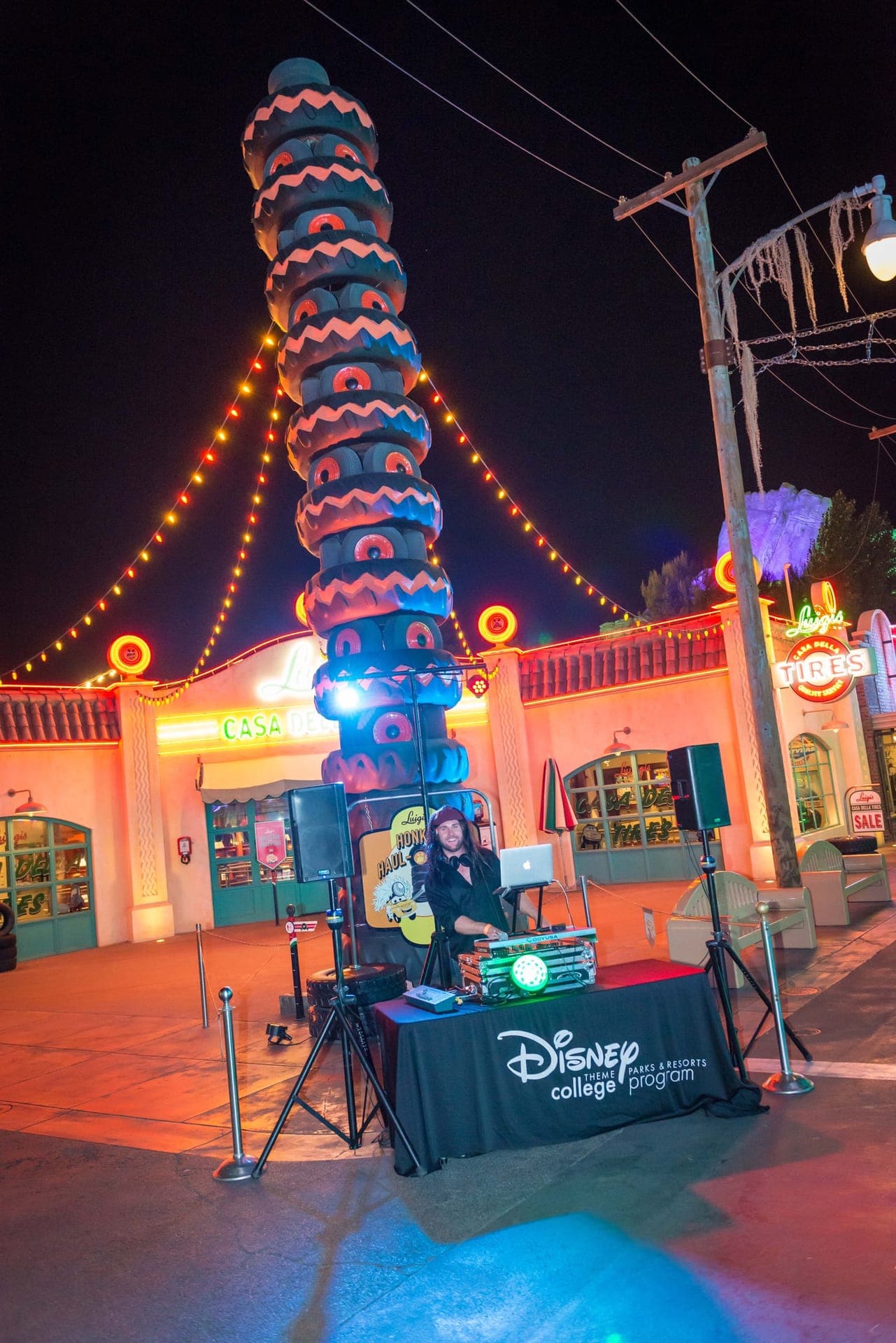 DJ setup under string lights at a theme-park celebration